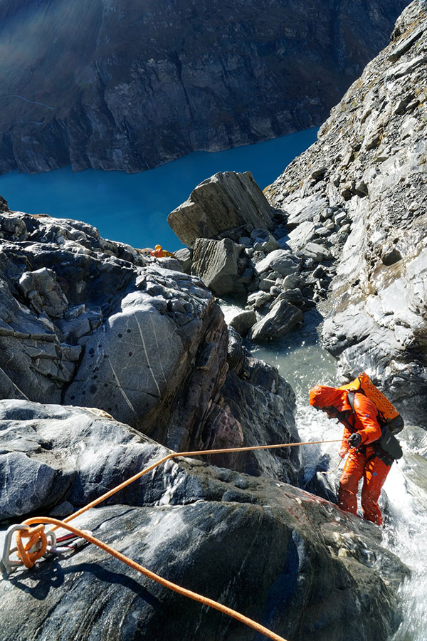 Image © Matthias Holzinger/CE4Y a person rappeling down a waterfall using an orange suit